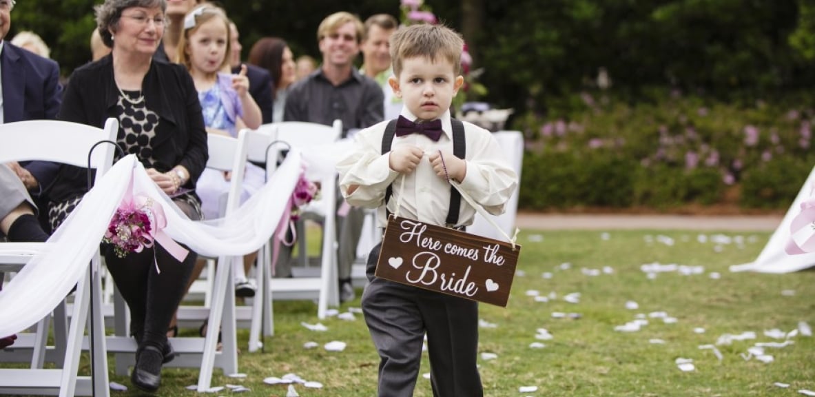 The young ring bearer walking down the aisle.