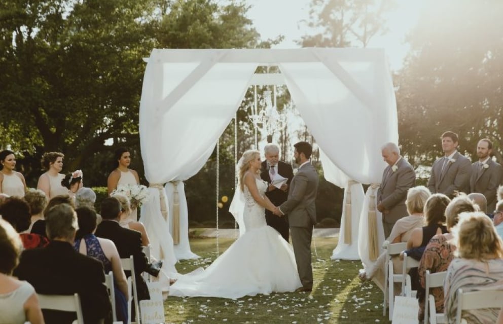 Caryn and Blake at the outdoor altar on the grand lawn at Hotel Effie.