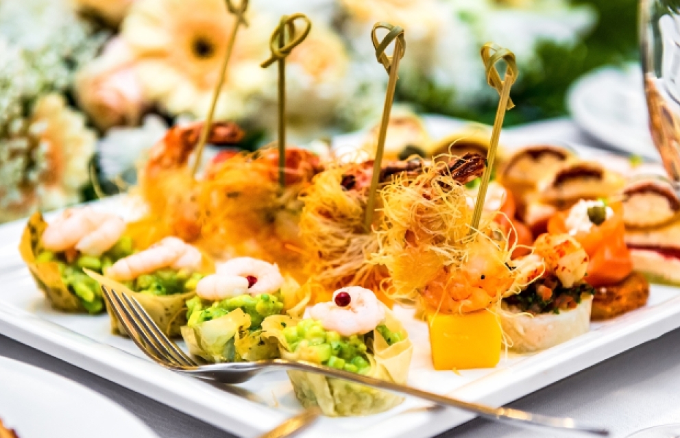 Close up on rows of neatly plated appetizers.