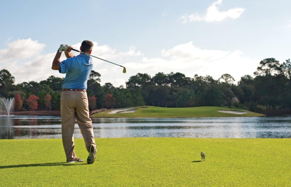 a gentleman takes a swing at Raven Golf Course