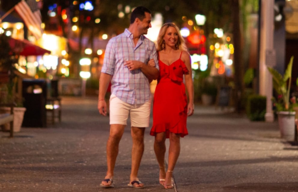 A young couple walking at night in Baytowne