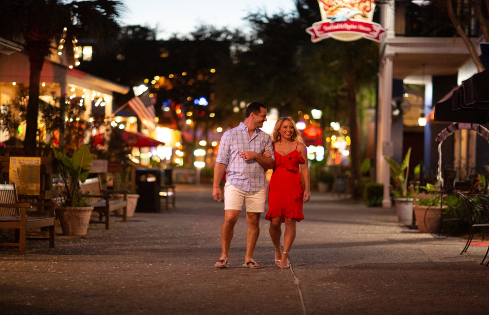 A couple walking around at Baytowne in the evening