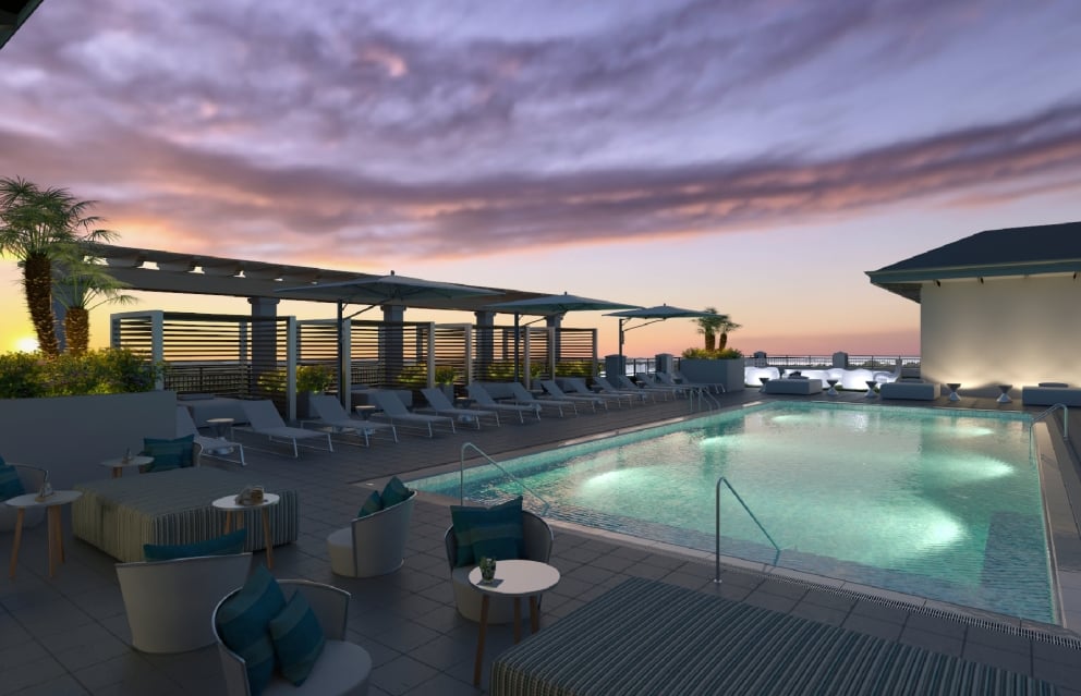 The rooftop pool and lounge at nighttime with a beautiful sunset.