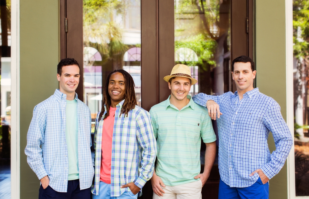 Four men standing outside of Island Clothiers