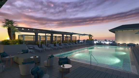 The rooftop pool and lounge at nighttime with a beautiful sunset. 