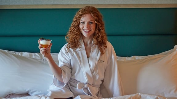 girl in bed holding yogurt