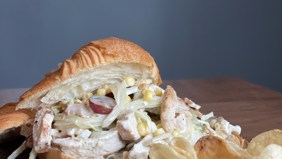 Chicken salad croissant sandwich with chips