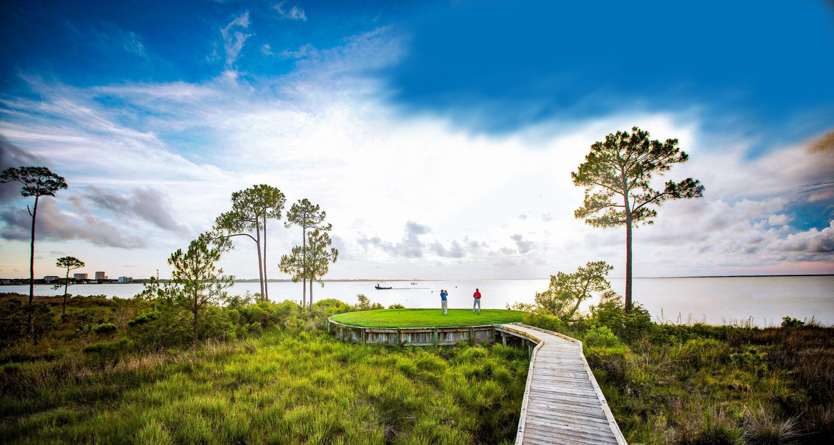 A wooden boardwalk leading to a hole on a beautiful Florida golf course.