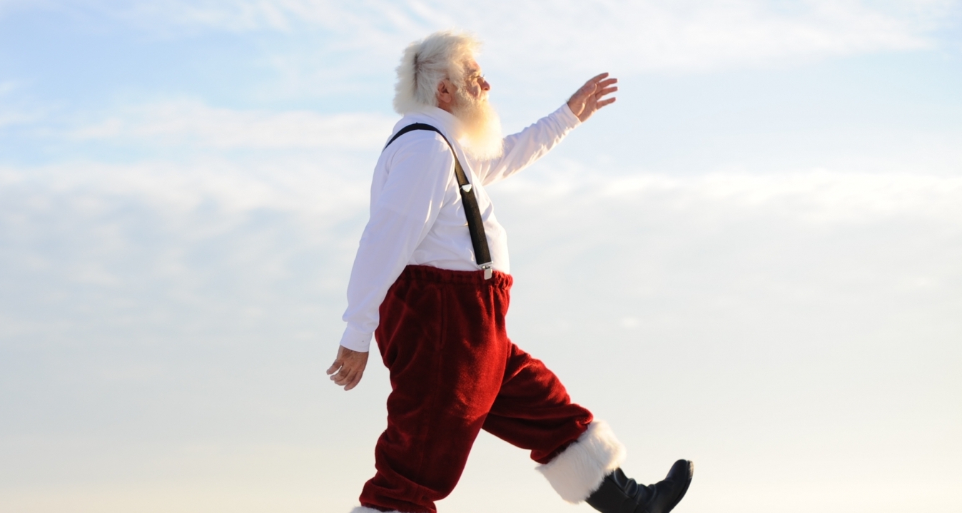 Santa walking on the beach.