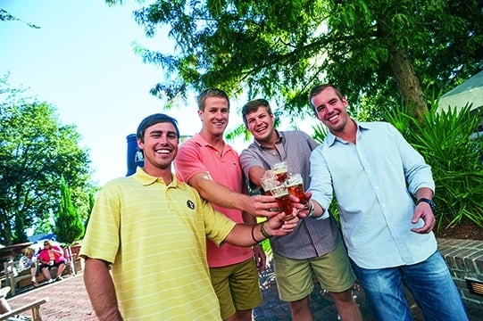 A group of guys smiling and holding their drinks