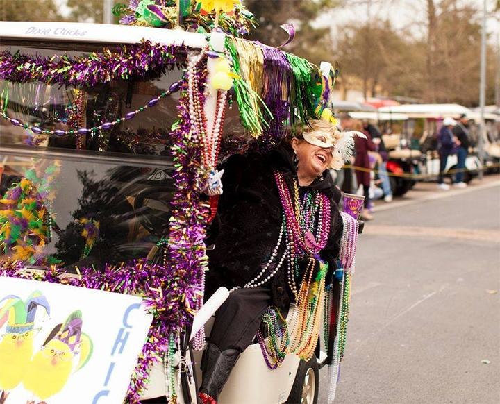 woman with decked out mardi gras golf cart 