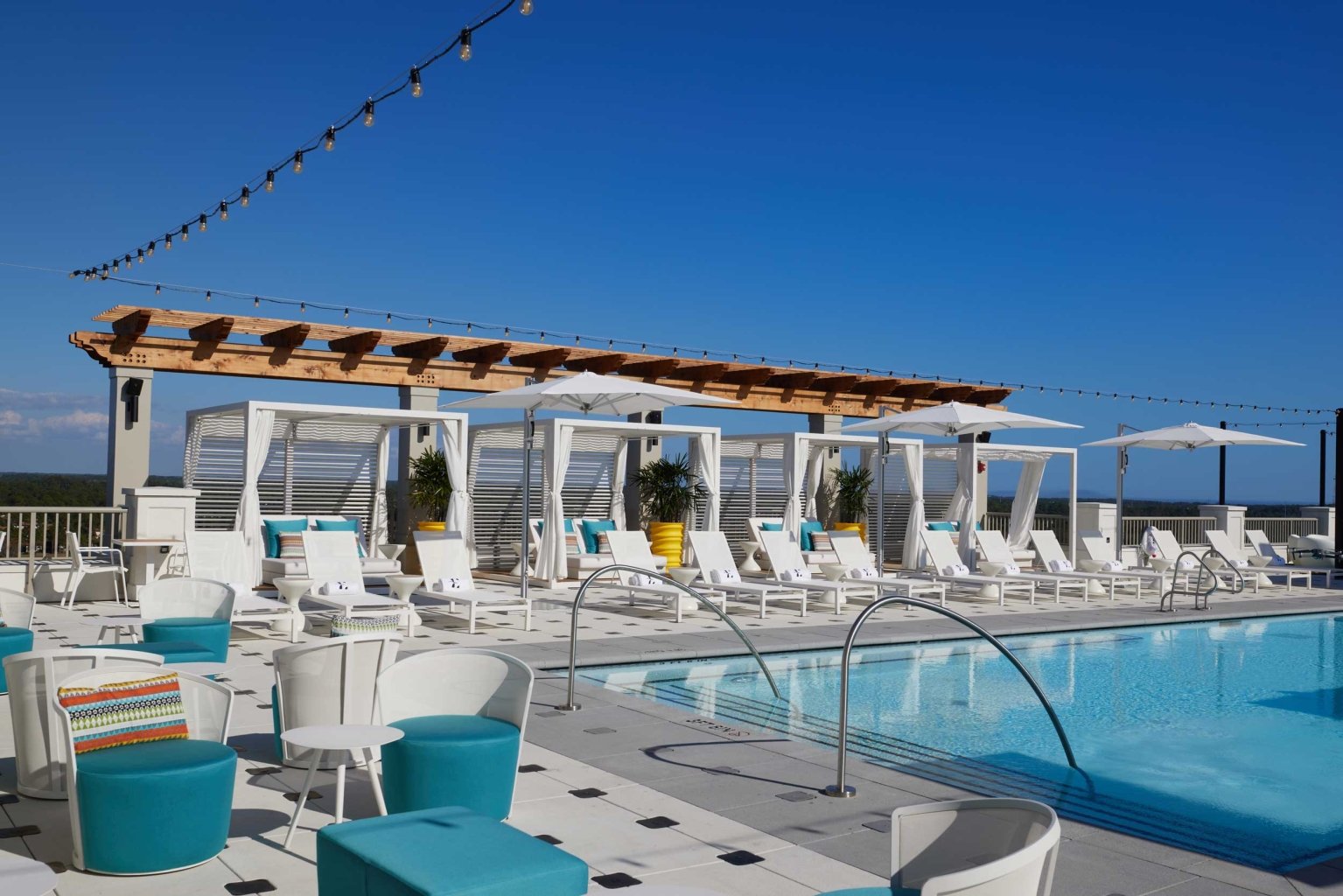 A rooftop pool with lounge chairs.