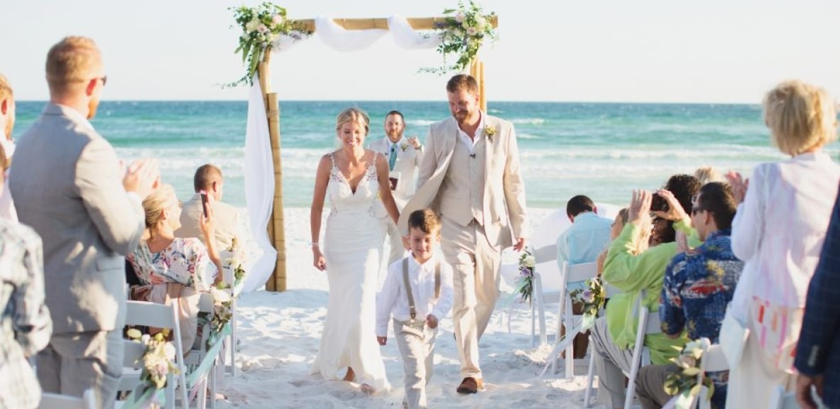 Callie and Roy walking down the aisle on a Destin, Florida beach.