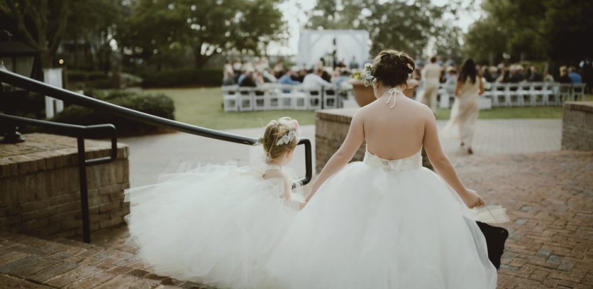 Flower girls walking down the Hotel Effie steps at a wedding.