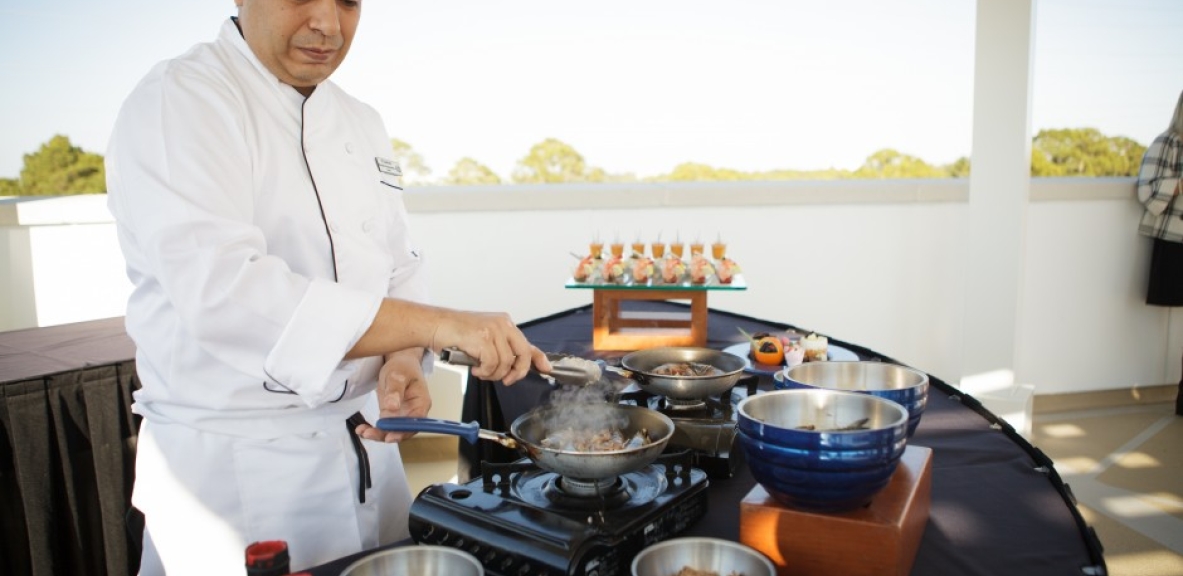 A chef prepares food on a skillet.