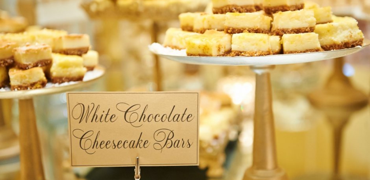 A plate stacked with white chocolate cheesecake bars.