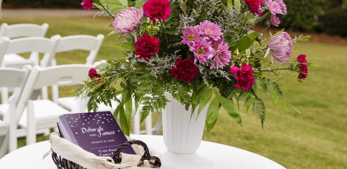 A table for an outdoor wedding ceremony set up with flowers.