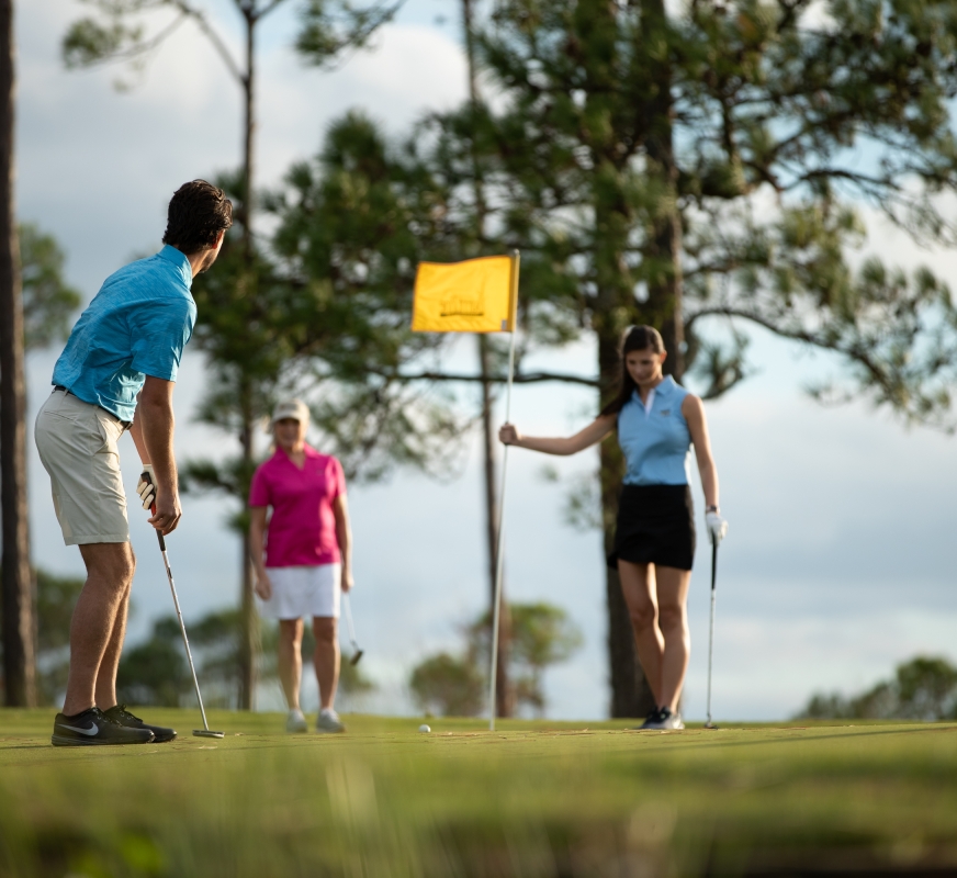 A man putting into the hole on a golf green