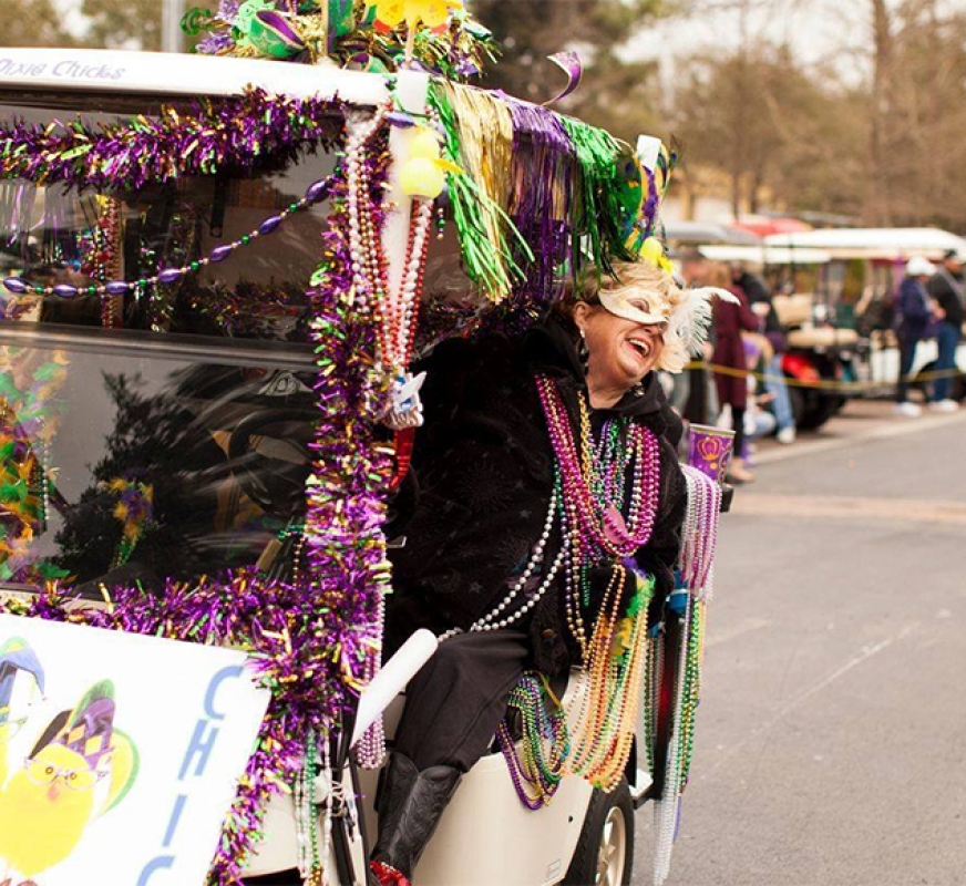 woman with decked out mardi gras golf cart 